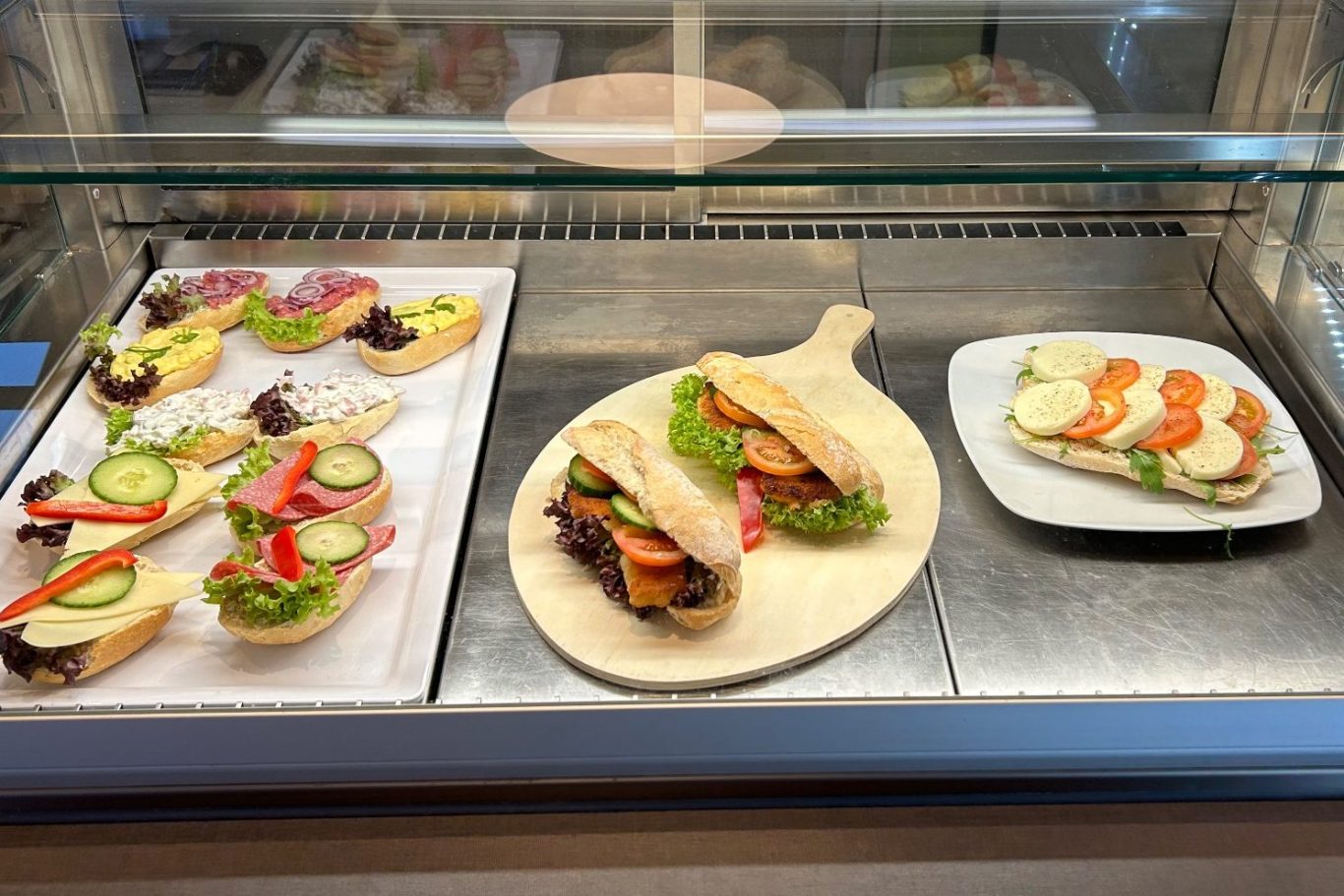 Brötchenplatte Auf dem Bild ist eine Vitrine zu sehen, in welcher diverse belegte Brötchen ausgestellt sind.